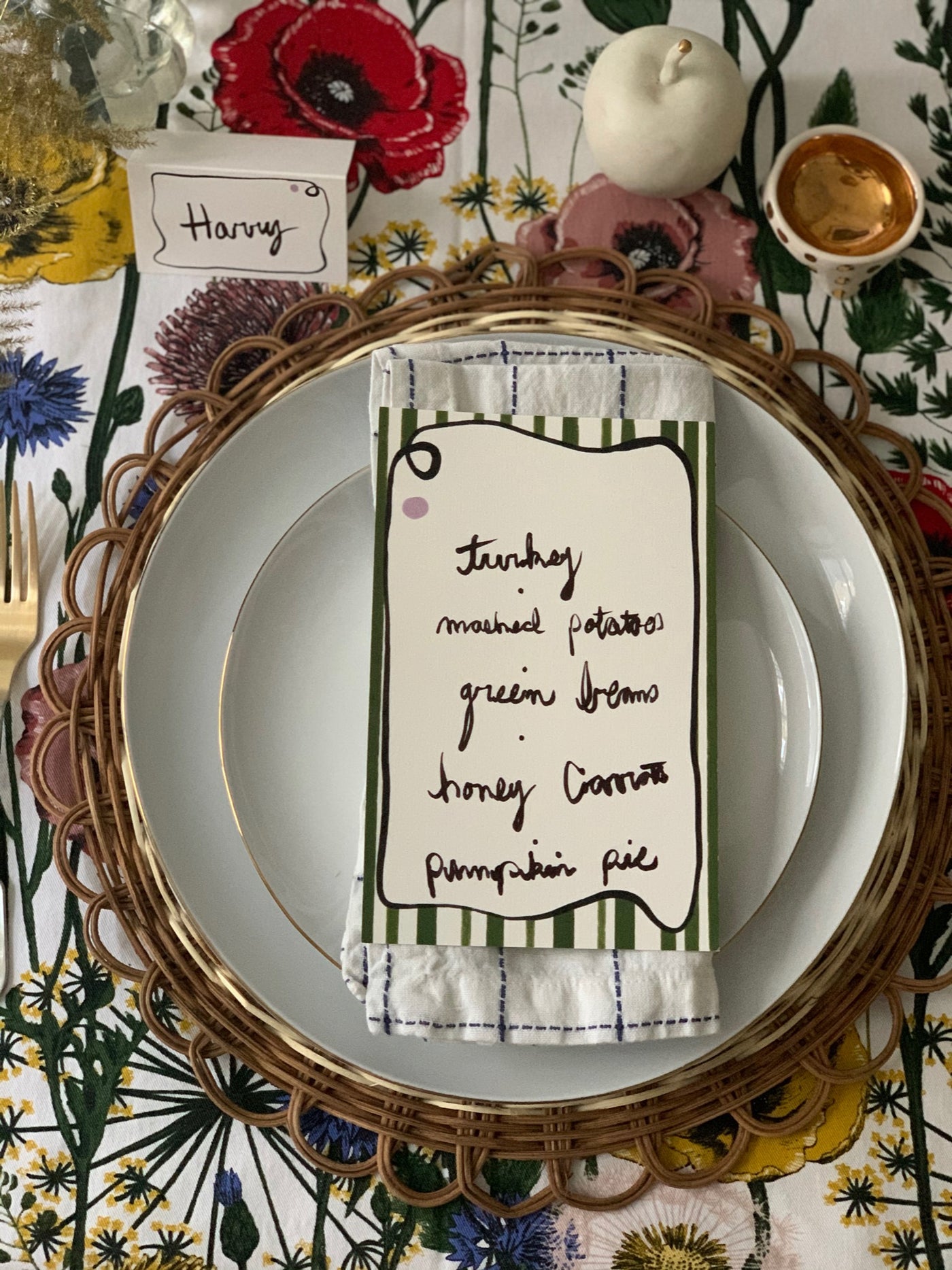 Picture of a dinner table dressed with a patterned tablecloth with Romeo and Jules stripe designed menu card and matching place card 